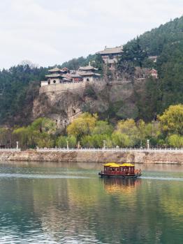 travel to China - pagodas on East Hill of Chinese Buddhist monument Longmen Grottoes (Dragon's Gate Grottoes, Longmen Caves) on Yi river in spring season