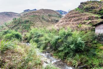 travel to China - water stream between terraced hills of Dazhai village in area of Longsheng Rice Terraces (Dragon's Backbone terrace, Longji Rice Terraces) in spring season