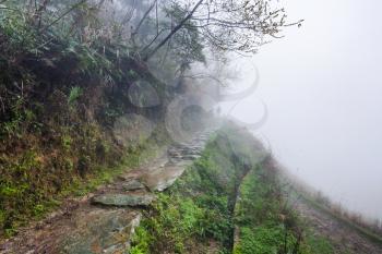 travel to China - wet pathway on hill slope in rainy misty spring day in area of Dazhai Longsheng Rice Terraces (Dragon's Backbone terrace, Longji Rice Terraces)
