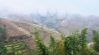 travel to China - view of hills with terraced rice fields over haze from Tiantouzhai village in area Dazhai Longsheng Rice Terraces (Dragon's Backbone terrace, Longji Rice Terraces) country in spring