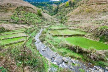 travel to China - view of terraced grounds and streem in Dazhai village in country of Longsheng Rice Terraces (Dragon's Backbone terrace, Longji Rice Terraces) in spring
