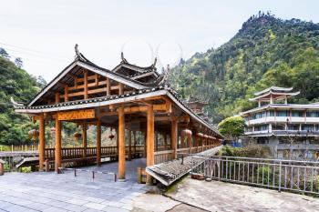 travel to China - entrace to Dong people style bridge in Jiangdi village over river in Longsheng Hot Springs National Forest Park of Xiangshan District in spring season