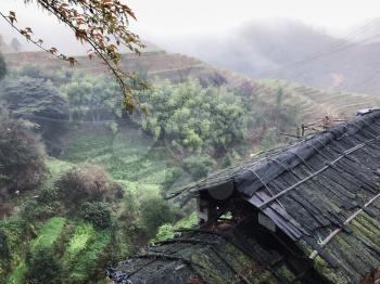 travel to China - view of wet shed and terraced fields from Tiantouzhai village in spring rain in area of Dazhai Longsheng Rice Terraces (Dragon's Backbone terrace, Longji Rice Terraces) country