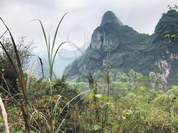 travel to China - green grass and karst mountain on background in Yangshuo County in spring season