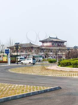LUOYANG, CHINA - MARCH 20, 2017: parking lot and hotel in area of Chinese Buddhist monument Longmen Grottoes (Dragon's Gate Grottoes, Longmen Caves) in valley Yi river in spring