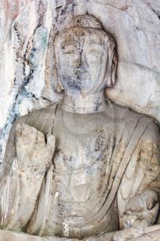 LUOYANG, CHINA - MARCH 20, 2017: Buddha statue in grotto in Chinese Buddhist monument Longmen Grottoes (Longmen Caves). The complex was inscribed upon the UNESCO World Heritage List in 2000