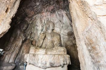 LUOYANG, CHINA - MARCH 20, 2017: statues in grotto in Chinese Buddhist monument Longmen Grottoes (Longmen Caves). The complex was inscribed upon the UNESCO World Heritage List in 2000