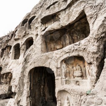 LUOYANG, CHINA - MARCH 20, 2017: carved wall of caves in West Hill of Chinese Buddhist monument Longmen Grottoes. The complex was inscribed upon the UNESCO World Heritage List in 2000