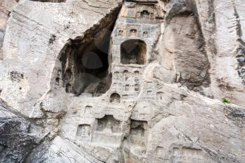 LUOYANG, CHINA - MARCH 20, 2017: reliefs and caves in wall of West Hill of Chinese Buddhist monument Longmen Grottoes. The complex was inscribed upon the UNESCO World Heritage List in 2000