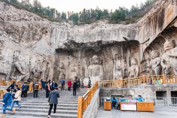LUOYANG, CHINA - MARCH 20, 2017: people near The Big Vairocana sculpture in main Longmen Grottoes (Longmen Caves). The complex was inscribed upon the UNESCO World Heritage List in 2000