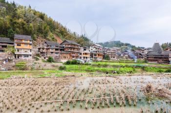CHENGYANG, CHINA - MARCH 27, 2017: people near rice paddy in Chengyang village of Sanjiang Dong Autonomous County in spring. Chengyang includes eight villages of the Dong people