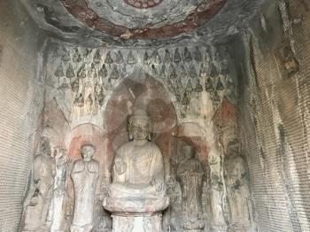 LUOYANG, CHINA - MARCH 20, 2017: sculptures with Sakyamuni statue in Middle Binyang Cave in Longmen Grottoes (Longmen Caves). The complex was inscribed upon the UNESCO World Heritage List in 2000