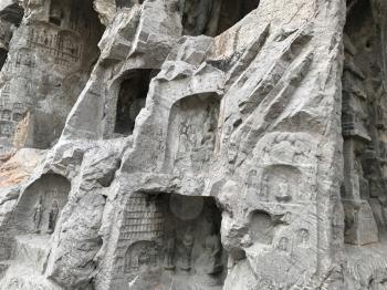 LUOYANG, CHINA - MARCH 20, 2017: carved caves and rooms in Chinese Buddhist monument Longmen Grottoes (Longmen Caves). The complex was inscribed upon the UNESCO World Heritage List in 2000