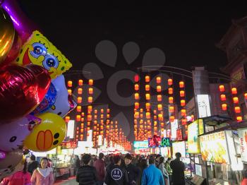 LUOYANG, CHINA - MARCH 20, 2017: people on illuminated West street in Luoyang city in spring night. Luoyang had a population about 6,5 mln inhabitants with 1,9 mln people on the outskirts