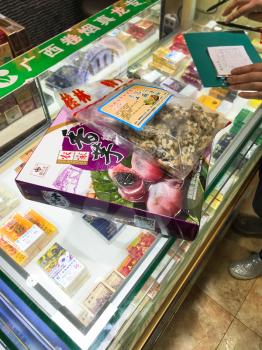 YANGSHUO, CHINA - MARCH 30, 2017: seller and local snacks on market stalls in Yangshuo city in spring. Town is resort destination for domestic and foreign tourists because of scenic karst peaks