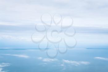 View from the airplane - view of horizon between blue cloudy sky and Aegean sea in Greece in autumn morning