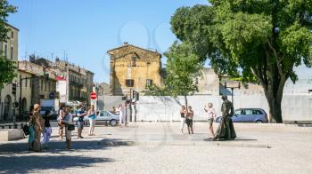 NIMES, FRANCE - JULY 8, 2008: tourists near statue to Christian Montcouquiol (Nimeno II, french matador) on square Place des Arenes in Nimes city
