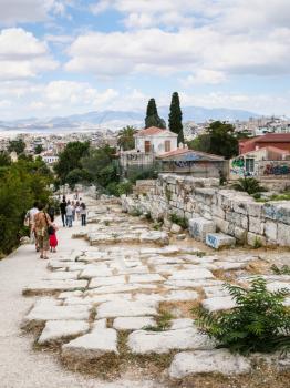 ATHENS, GREECE - SEPTEMBER 9, 2007: tourists on road to Acropolis in Ancient Agora in Athens. This is monumental gateway, included in Temple of Olympian Zeus comlex, resembling a Roman triumphal arch