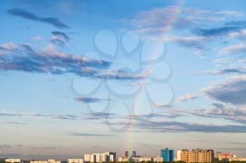 rainbow in blue evening sky over residential district in Moscow city in summer