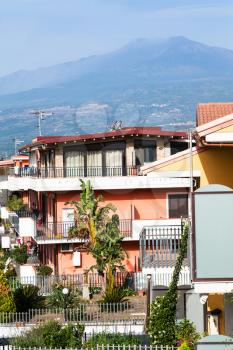 travel to Sicily, Italy - town houses on street via Ischia in Giardini Naxos city and view of Etna Mount in summer
