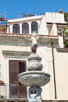 travel to Sicily, Italy - top figure of baroque style fountain (Quattro Fontane di Taormina) on Piazza Del Duomo in Taormina city in summer day