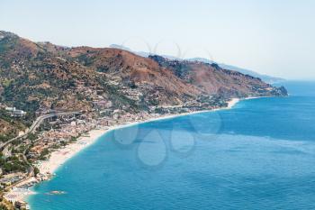 travel to Sicily, Italy - above view of Letojanni resort village of coast of Ionian Sea from Taormina city in summer day