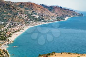 travel to Sicily, Italy - above view of Letojanni resort village of shore of Ionian Sea from Taormina city in summer day
