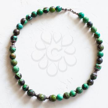 top view of old necklace from natural turquoise beads on concrete board