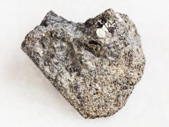 macro shooting of natural mineral rock specimen - rough peridotite stone with phlogopite mica on white marble background from Kovdor region, Kola Peninsula, Russia