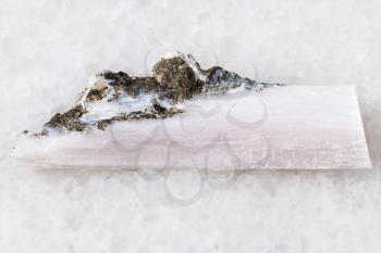 macro shooting of natural mineral rock specimen - rough crystal of xonotlite gemstone on white marble background from Norilsk district, Russia