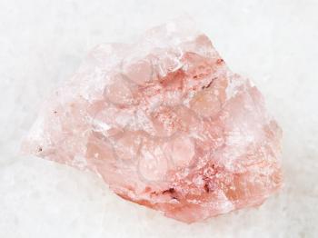 macro shooting of natural mineral rock specimen - crystal of rose quartz gemstone on white marble background from Kiv-Guba mine, Karelia, Russia