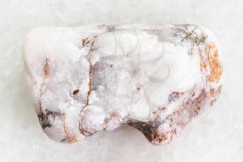macro shooting of natural mineral rock specimen - rough marble stone on white marble background from Greece
