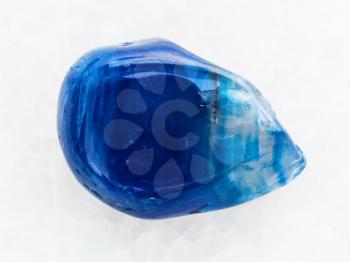 macro shooting of natural mineral rock specimen - polished blue toned agate gemstone on white marble background