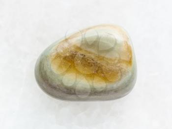 macro shooting of natural mineral rock specimen - polished gray Agate gemstone on white marble background