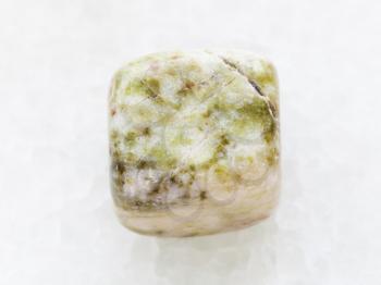 macro shooting of natural mineral rock specimen - polished agate gem stone on white marble background