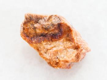 macro shooting of natural mineral rock specimen - raw orthoclase stone on white marble background