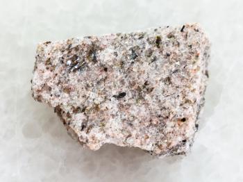 macro shooting of natural mineral rock specimen - raw Schist stone on white marble background