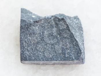 macro shooting of natural mineral rock specimen - raw Slate stone on white marble background