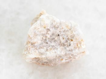macro shooting of natural mineral rock specimen - rough Conglomerate stone on white marble background