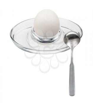 whole boiled white egg and spoon in glass egg cup isolated on white background