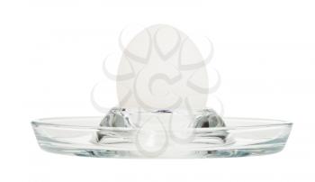 side view of boiled white egg in glass egg cup isolated on white background