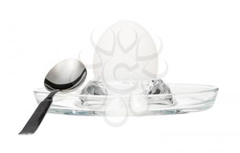 side view of boiled white egg and spoon in glass egg cup isolated on white background