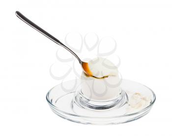 soft-boiled white egg with spoon in glass egg cup isolated on white background