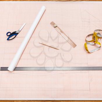 top view of objects to draw a clothing pattern on sheet of graph paper