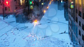Moscow landscape - blurred reflection of urban houses in puddle of melting snow on urban road in winter evening