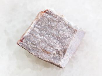 macro shooting of natural mineral rock specimen - raw Rhyolite stone on white marble background