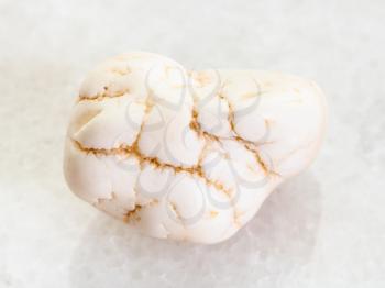 macro shooting of natural mineral rock specimen - polished magnesite stone on white marble background