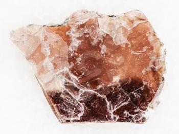 macro shooting of natural mineral rock specimen - rough brown mica lamina on white marble background