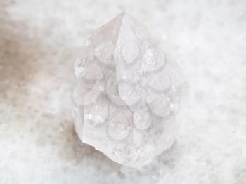 macro shooting of natural mineral rock specimen - rock crystal of quartz gemstone on white marble background