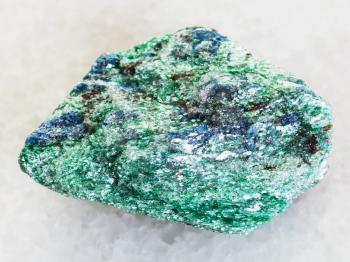 macro shooting of natural mineral rock specimen - raw Fuchsite (chrome mica) stone on white marble background from Hizovaara, Republic of Karelia in Russia